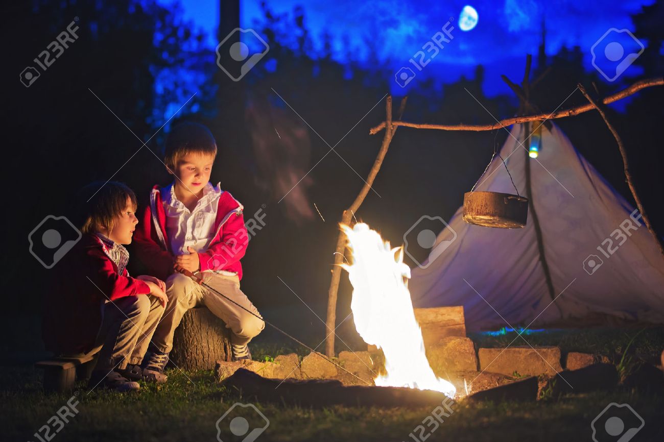 Niños escuchando historias alrededor de una fogata